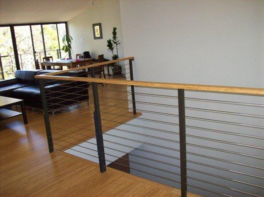 Regular paint steel with 1/8" stainless steel cable railing @ 3" center to center, include wood on top rail.