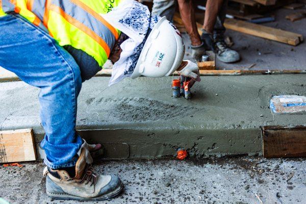 Pro-Pave Inc. Contractor Smoothing Concrete With a Float