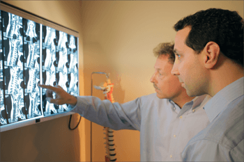 Dr. David Simon & Dr. Dean Curtis review patient x-rays at Randolph Pain Relief & Wellness Center.