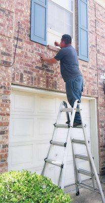 Removal Specialist Inspecting and Determining the best way to Extract the Live Honey Bees going inside of this Window!