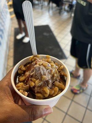 Soft serve chocolate with wet walnuts a chocolate syrup.