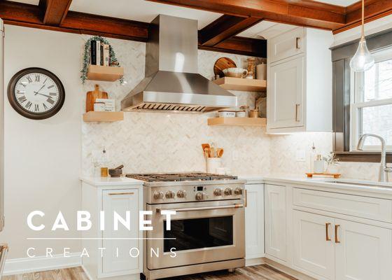 The range is a focal point of this kitchen. It is flanked by floating shelves and calacatta marble, herringbone backsplash.