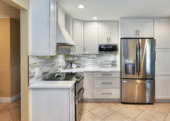 White Shaker cabinets with beautiful quartz counters and fantasy brown natural stone backplash.