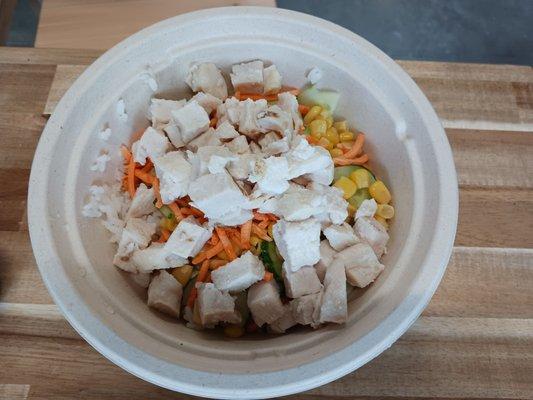 Chicken bowl with white rice, corn, cucumbers and carrots