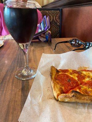 Burgundy house wine and Grandma's pizza slice.