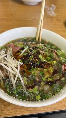 N4 (Rare Steak Pho) dressed with bean sprouts , cilantro, two squeezes of lime, hoisin sauce, soy sauce, and chili oil .