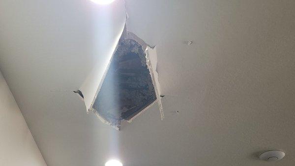 Hole in the ceiling from worker stepping thru ceiling