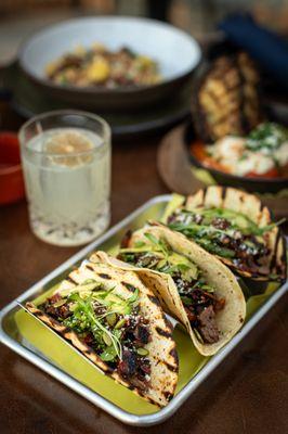 Carne Asada Tacos with Mole Poblano - roasted chilies, avocado, queso fresco, chimichurri. Paired with our Margarita