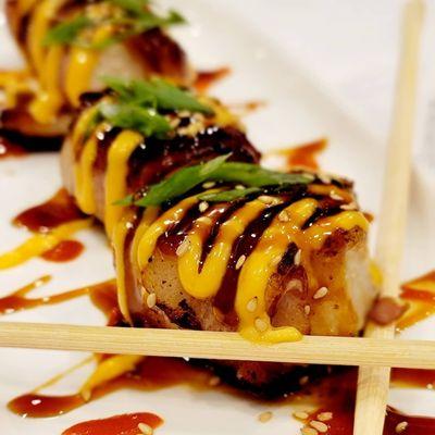 Bacon-wrapped scallops with spicy mayo, Sriracha, eel sauce and chili oil drizzle