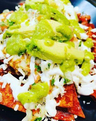 Chilaquiles. Red with guacamole mozzarella cheese, 2 eggs beans and sour cream