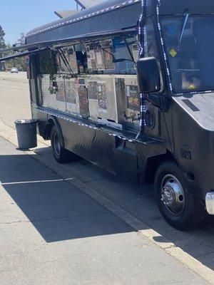 Food truck parked in front of liquor store.