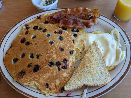 Blueberry pancakes, eggs, bacon, and toast