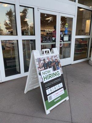 Outside: Now Hiring signage in front of the entrance