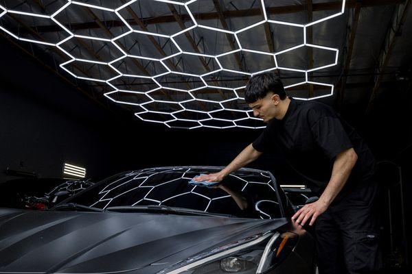 John wiping down the windshield after an installation of our premium ceramic films