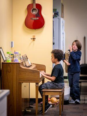 Two elementary students play instruments together.