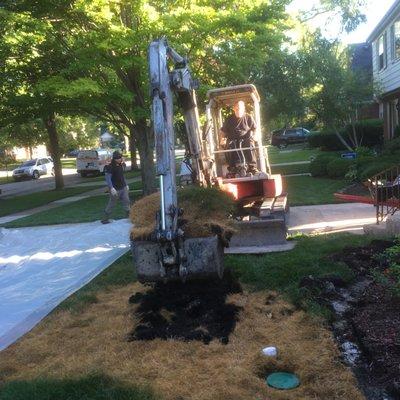 Digging out the underground oil tank. Notice the dead grass from the leaking oil in the buried tank. It smelled too.