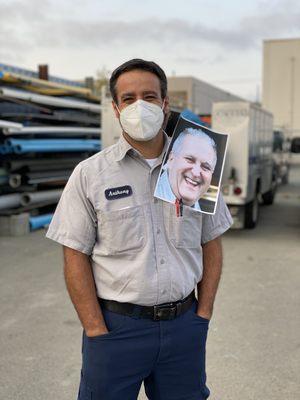 Anthony celebrates Louie by posing with his photo. Louie worked at Caccia Plumbing helping with inventory management and deliveries