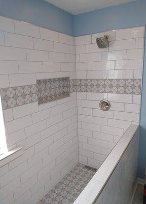 We tore out an old garden tub and small shower, and installed a large custom tile walk in shower (glass installed later on the half wall).