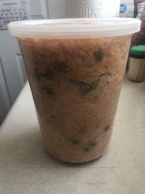 Plastic container of red rice mixed w/ peas and carrots