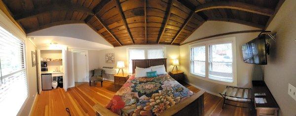 This is a panoramic view of the interior with a queen size bed.