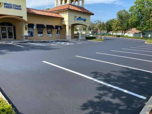 plaza parking lot seal coated and striped