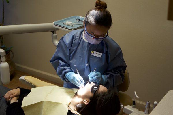 The hygienist cleaning a patients teeth.