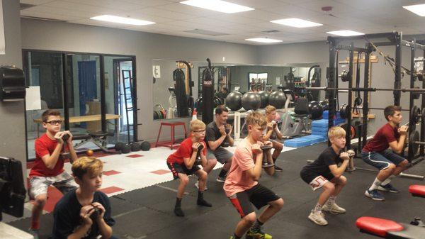 Middle School Strength class working on their squatting form.