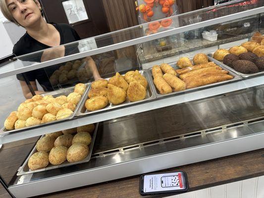 The lady in the picture was the nicest employee there! The big balls on the bottom shelf is the stuffed pão de queijo! Best thing ever!!!