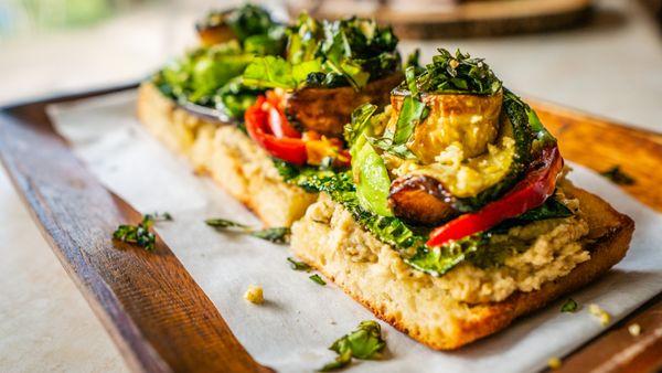 Roasted eggplant, kale, zucchini, sweet & spicy cherry peppers, cashew parmesan, basil, olive oil on a homemade breadfruit sourdough