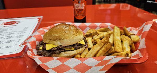 A double cheeseburger with fries and a cold beer