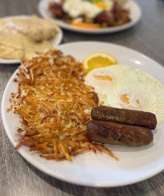 Biscuits and gravy with hash brown, eggs, and sausage links