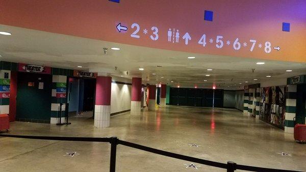 Brightly marked theater numbers and restroom symbols on the wall.