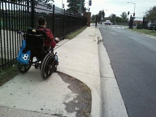 cracked sidewalk that leads to rampless and dangerous car crossing right in middle of Wash Hosp Ctr. Needs major fixing!