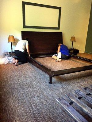 Blake and his assistant expertly disassembling a bedframe