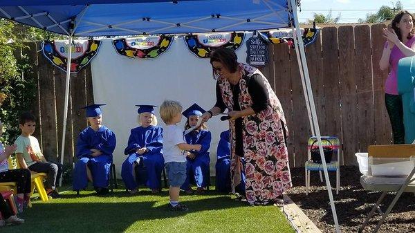 Passing out diplomas at our annual Preschool and Pre-K award ceremony and Graduation!  ("YAY PAPER" says Wolf)