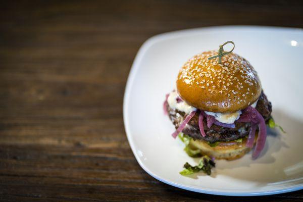 The Perfect Burger: Angus beef, gruyère cheese, bacon onion jam, picked red onions, shredded red leaf lettuce & roasts garlic aioli.