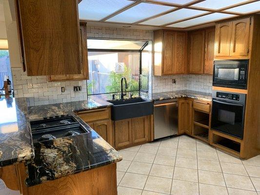 It feels like a brand new kitchen after some unfortunate water damage.  New counters, backsplash, farmhouse sink, and repairs to cabinetry.