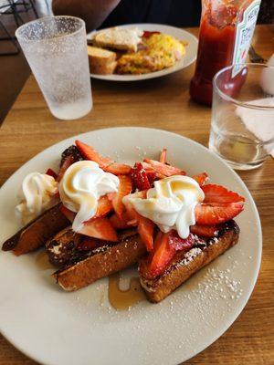 French toast with strawberries and whipped cream.