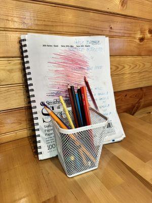 Sketch pads and colored pencils at every table.