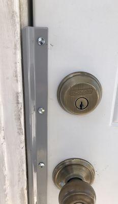 This is a latch shield installed on a residential out-swing door.