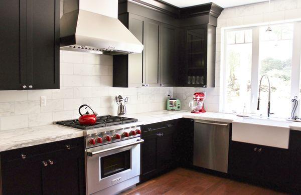 Custom black kitchen cabinets, marble slab counter top, marble tile splash