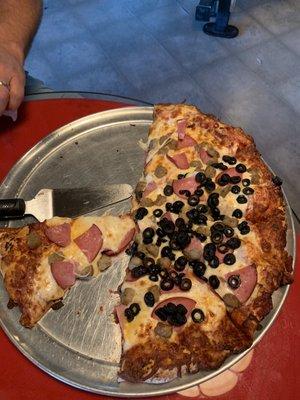 Canadian bacon, sausage, olives on half, and fresh tomatoes on the side