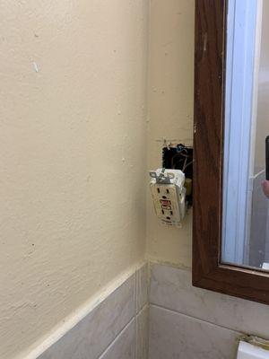 Bathroom AC outlet hanging off the wall