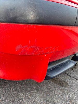 Scratched bumper with cheap sharpie trying to cover his mistake.