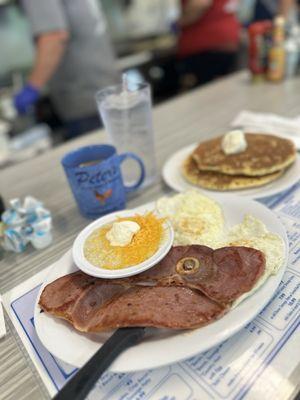 generous portion of country ham, choice of grits or potatoes,  2 eggs any style, and short stack of pancakes...add fruit or pecans for $1.