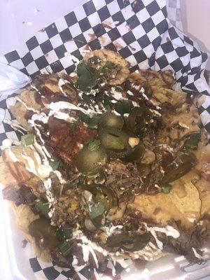 Brisket nachos with queso, bbq sauce, jalapeños, sour cream and cilantro