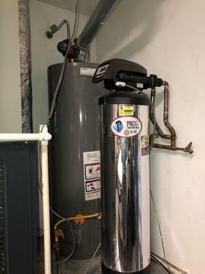 The newly installed water heater is behind he water softener.