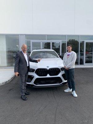 Happy young guy with his new BMW M X6