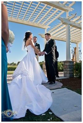 Bride and groom exchange vows under gazebo at Eagle Creek Golf Club