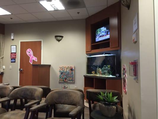 Waiting room has a tv and an aquarium.